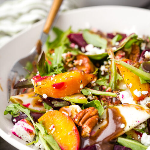 A cozy fall beet salad with mixed greens, goat cheese, two kinds of beets, and toasted pecans.