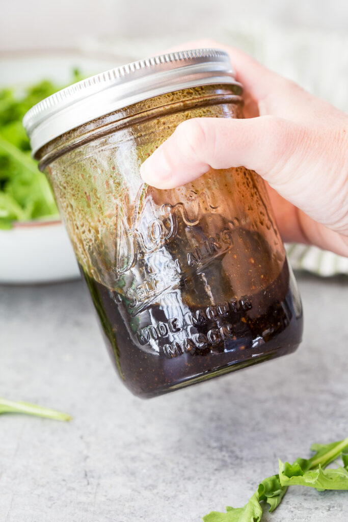 Mixing up the balsamic vinaigrette, shaking it to combine. 