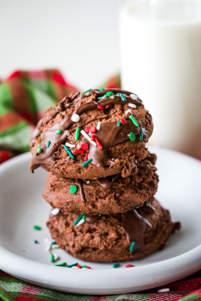 A plate of chocolate christmas cookies drizzled with peppermint chocolate and sprinkles