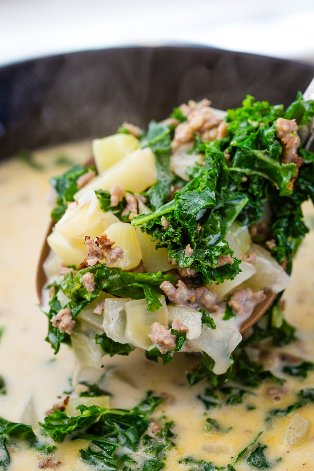 A ladle full of zuppa toscana, an olive garden copycat soup