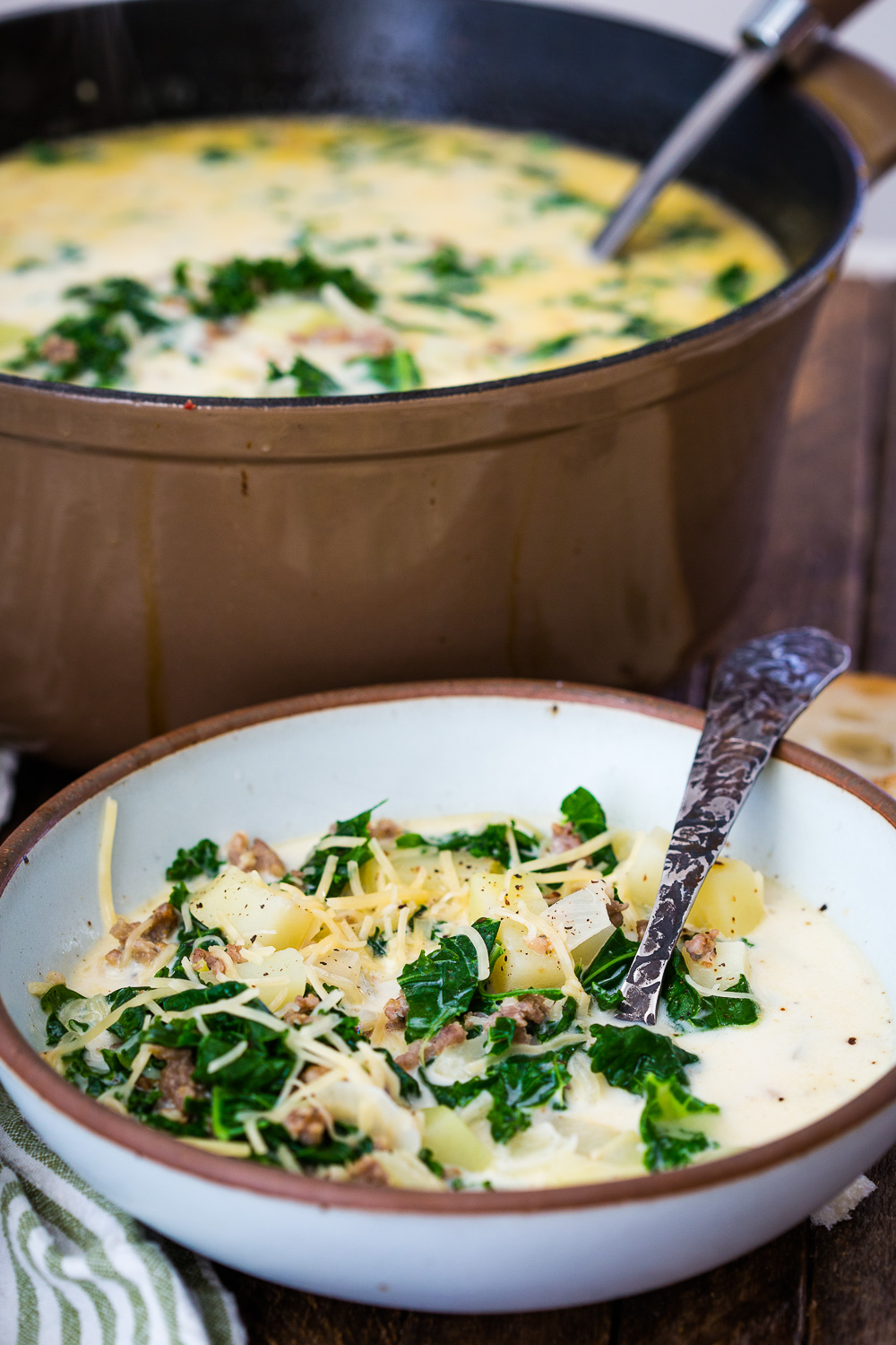 A big pot and bowl og zuppa toscana, a delicious creamy soup