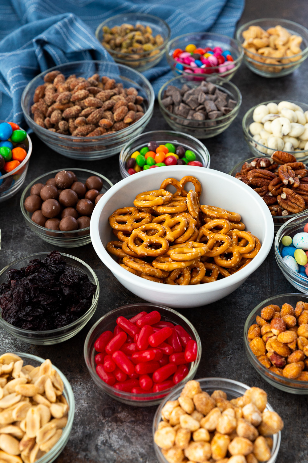 Ingredients for a delicious homemade trail mix recipe, complete with nuts, fruit, chocolate, and fun treats. 