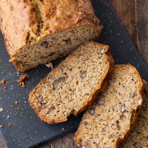 A loaf of browned butter banana bread with a few slices