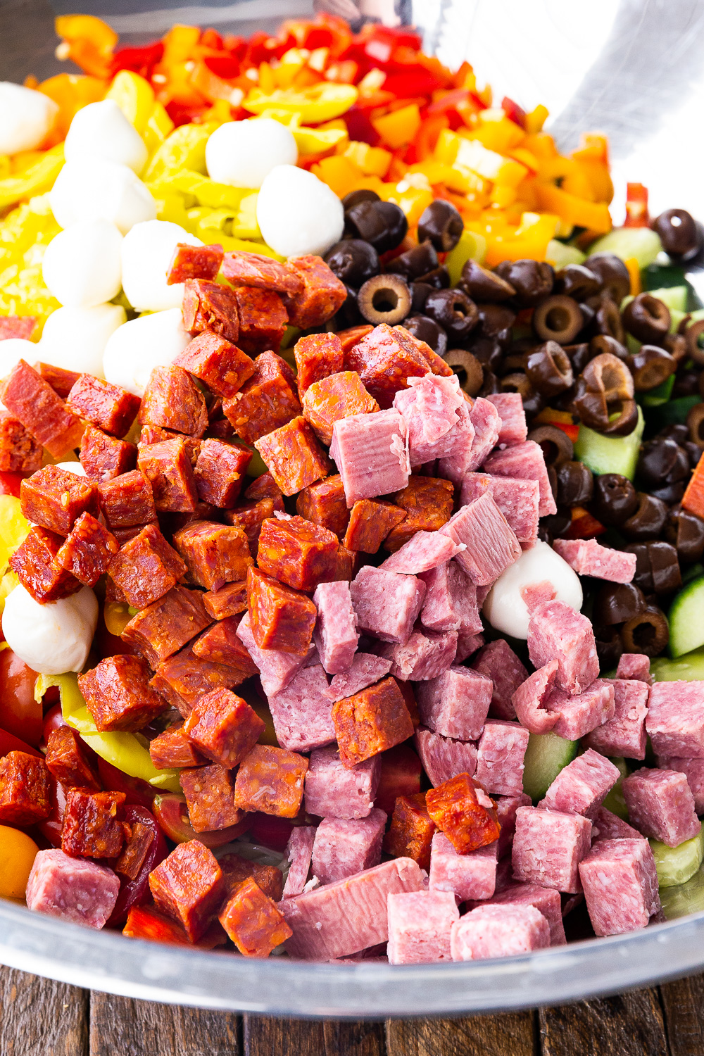 Mixing together all of the ingredients for a pasta salad. 