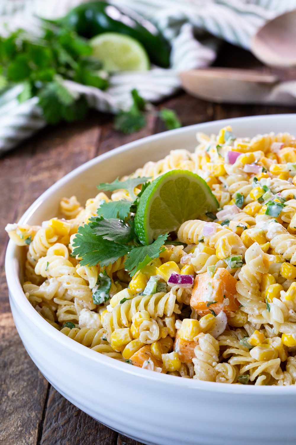 Mexican Street Corn Pasta Salad garnished with lime and cilantro. Creamy pasta salad reminiscent of elote. 