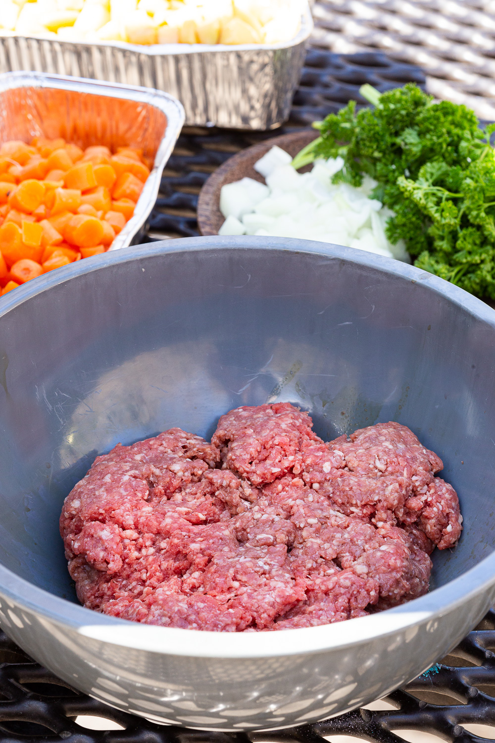 Seasoning ground beef for campfire foil dinners.