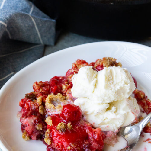 A delicious cherry cobbler, with oatmeal crumble on top and vanilla ice cream.