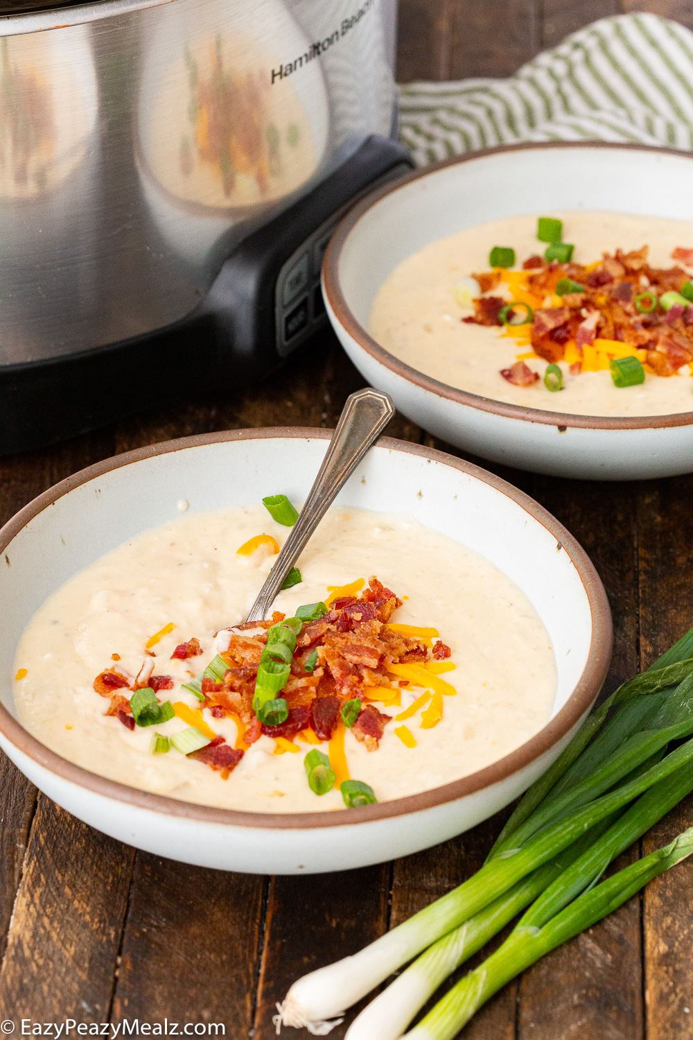 Crock pot loaded baked potato soup topped with crispy bacon, chives, and cheese