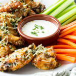 Garlic Parmesan Chicken Wings, crispy baked wings with a butter herb garlic parmesan sauce.