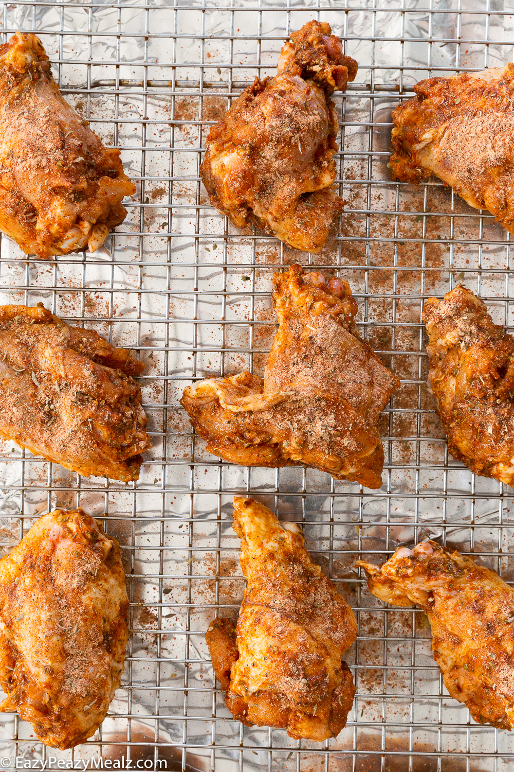 Cajun chicken wings, seasoned and on a sheet pan ready to bake. 