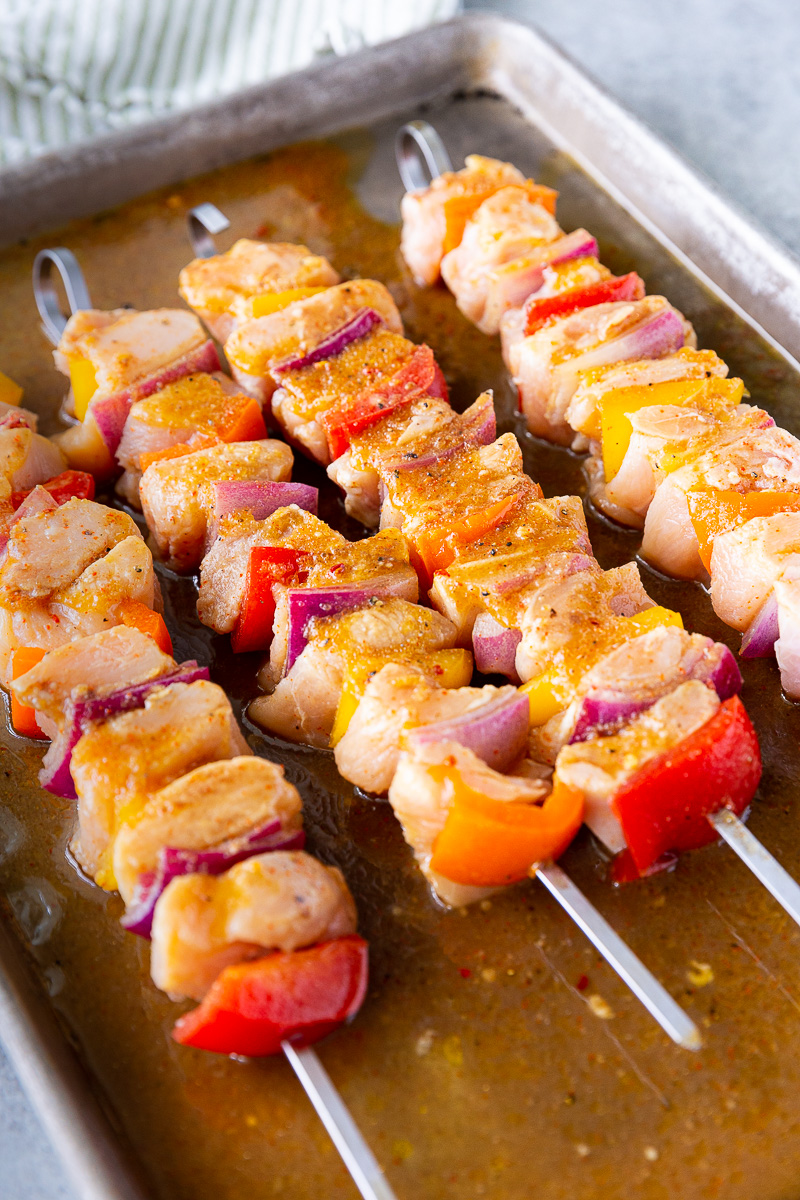 Chicken skewers being marinated