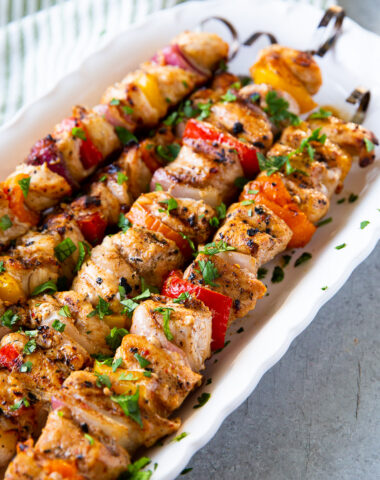 Grilled chicken skewers with charred bell peppers and onions, served hot off the grill with a golden, caramelized finish.