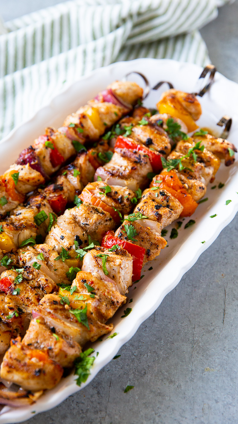 Grilled chicken skewers with charred bell peppers and onions, served hot off the grill with a golden, caramelized finish.