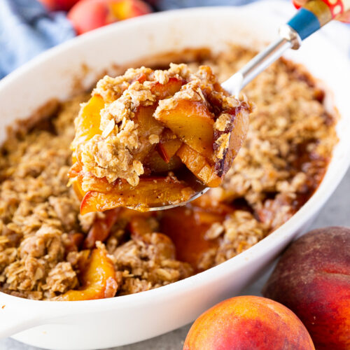 Golden, buttery peach crisp topped with a crisp oat crumble and served warm with a scoop of melting vanilla ice cream.
