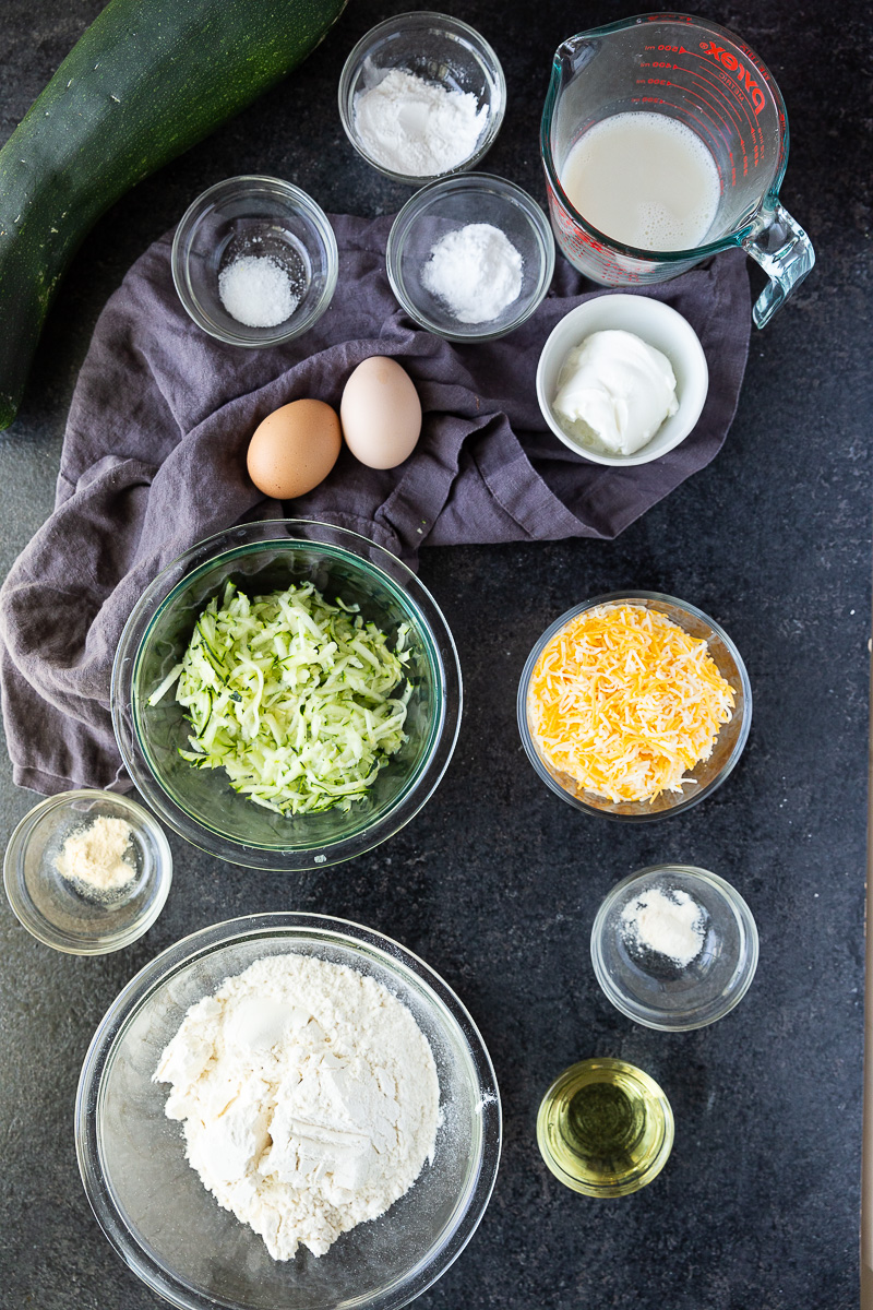 Ingredients for Moist and fluffy zucchini muffins loaded with melted cheese and flecks of green zucchini—savory, satisfying, and packed with flavor.