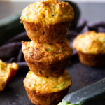 Zucchini muffins stacked and ready to serve—these savory bites are perfect for lunchboxes, brunch, or an on-the-go snack.