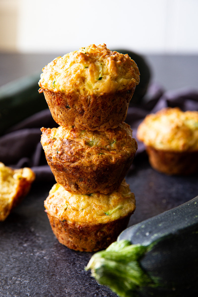 Zucchini muffins stacked and ready to serve—these savory bites are perfect for lunchboxes, brunch, or an on-the-go snack.