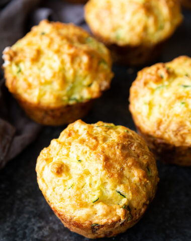 Golden, cheesy zucchini muffins fresh from the oven, with a perfectly crisp top and soft, savory center—ideal for breakfast or snacking.