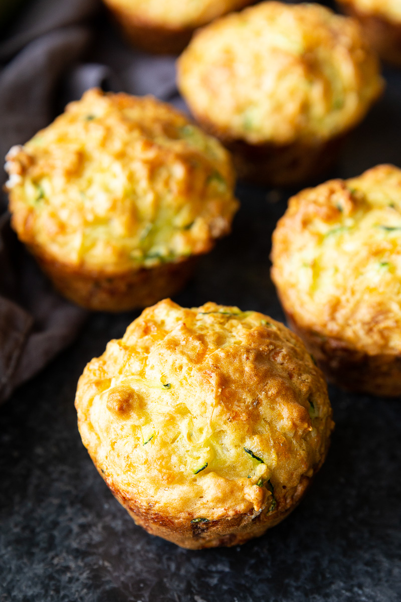 Golden, cheesy zucchini muffins fresh from the oven, with a perfectly crisp top and soft, savory center—ideal for breakfast or snacking.