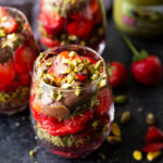 Decadent Dubai Chocolate Strawberry Cups layered with crispy kataifi pastry, creamy pistachio butter, fresh strawberries, and silky milk chocolate ganache, beautifully served in elegant glass cups.