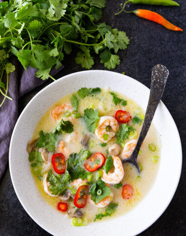 Creamy and aromatic Tom Kha soup, brimming with coconut milk, tender chicken, fresh herbs, and zesty lime, offering a comforting balance of savory, tangy, and slightly spicy flavors.