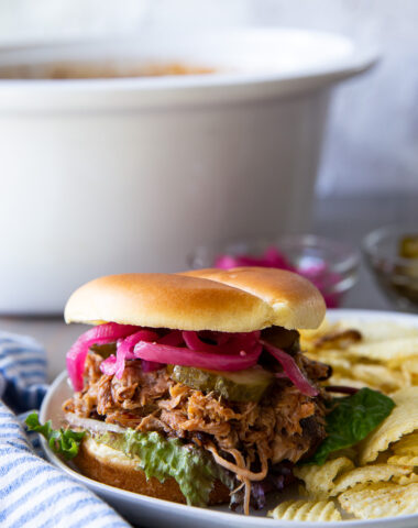 Juicy slow cooker pulled pork piled high on a soft bun, coated in rich barbecue sauce, perfect for sandwiches, sliders, or a hearty meal.
