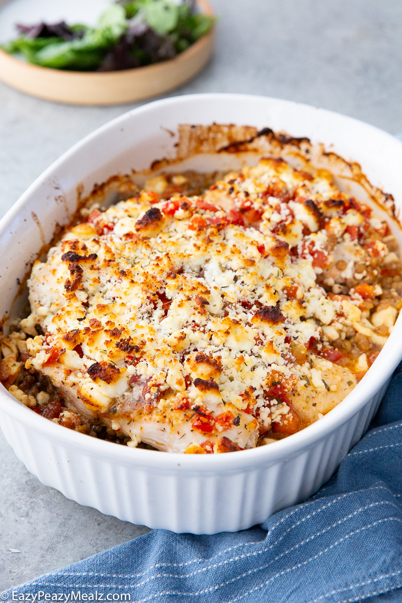 A casserole dish of baked feta chicken, a bruschetta and lentil dish.