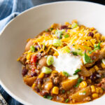 Cowboy casserole, cooked in the slow cooker, and topped with cheese and sour cream