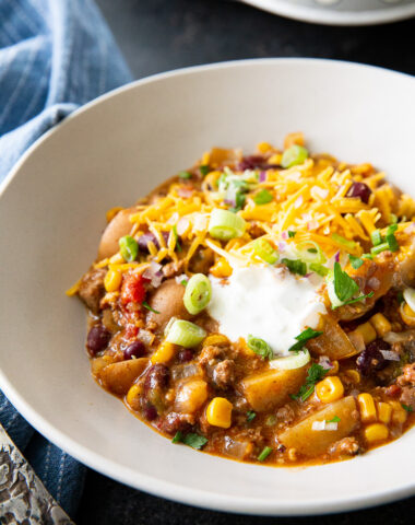 Cowboy casserole, cooked in the slow cooker, and topped with cheese and sour cream