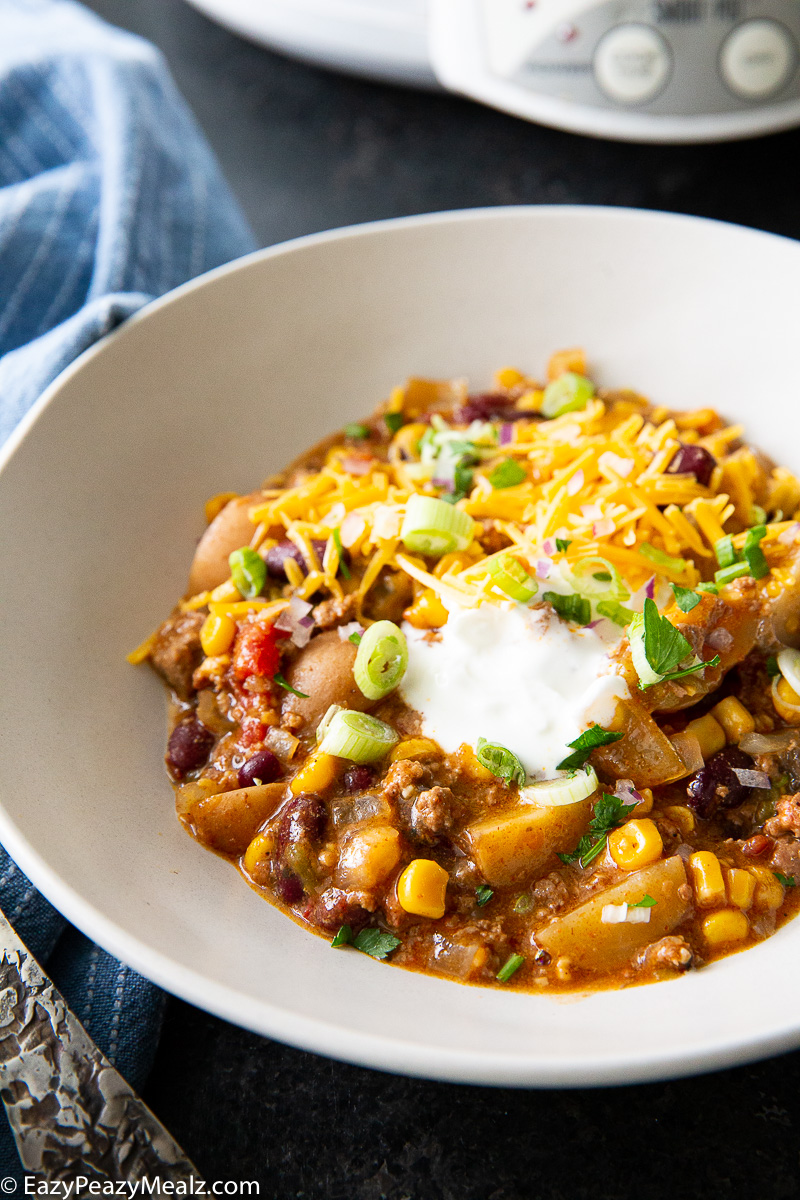 Cowboy casserole, cooked in the slow cooker, and topped with cheese and sour cream