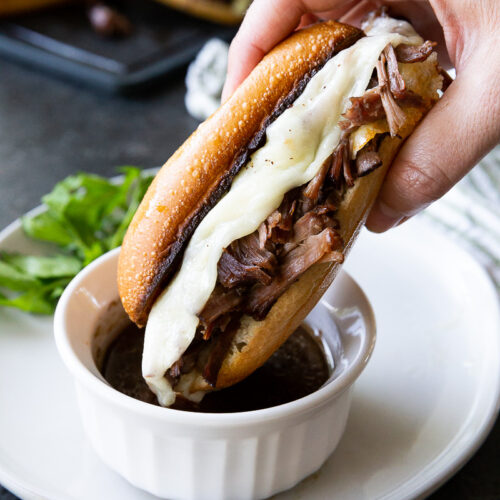 uicy, tender beef piled high on a crusty roll, topped with melty cheese, and served with rich au jus for dipping—French Dip Sandwiches
