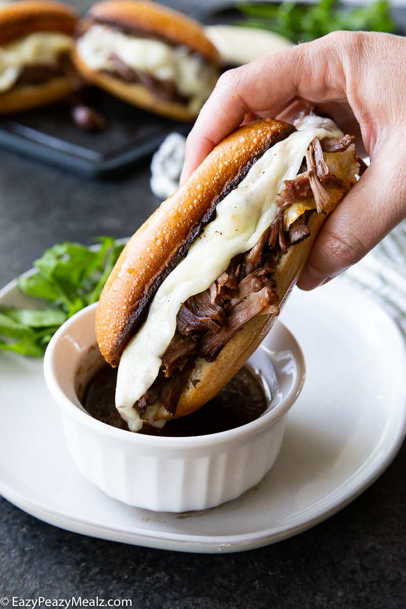 uicy, tender beef piled high on a crusty roll, topped with melty cheese, and served with rich au jus for dipping—French Dip Sandwiches