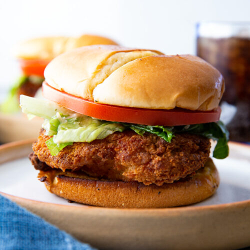 Caesar Chicken Sandwich, a crispy chicken filet with caesar salad, tomatoes, and a toasted bun.