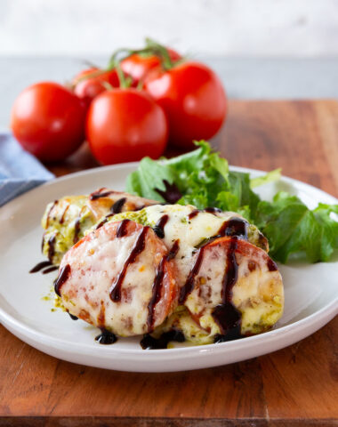 Caprese Chicken, baked chicken with pesto, mozzarella, and tomatoes with balsamic glaze.