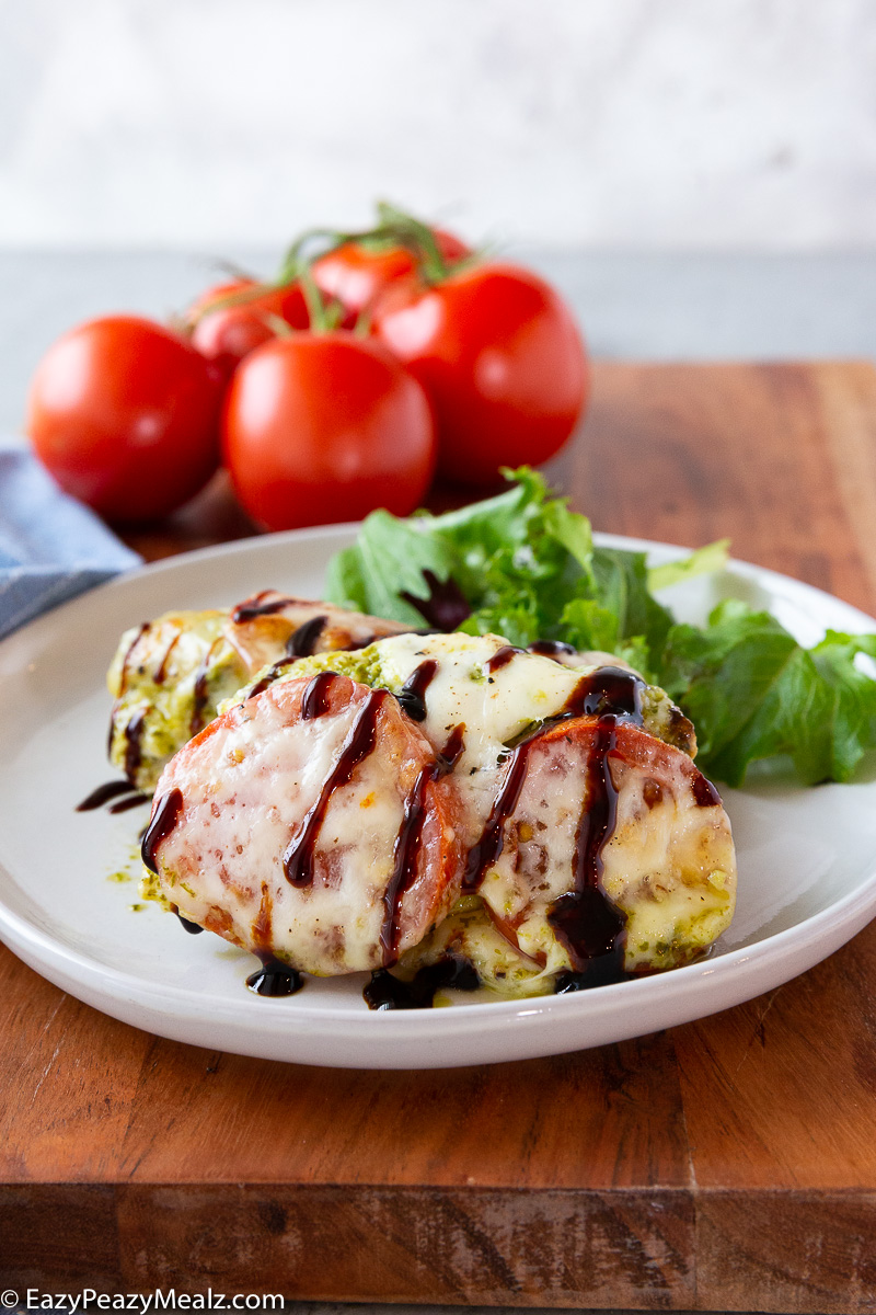 Caprese Chicken, baked chicken with pesto, mozzarella, and tomatoes with balsamic glaze. 