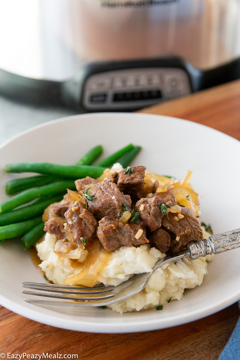 Slow cooker french onion beef tips, over creamy mashed potatoes.