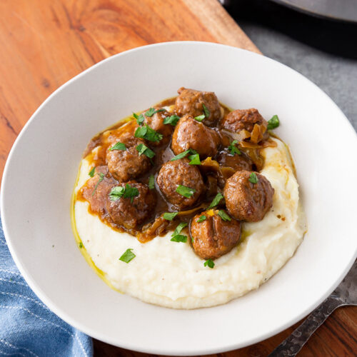 A plate full of mississippi meatballs spooned over mashed potatoes