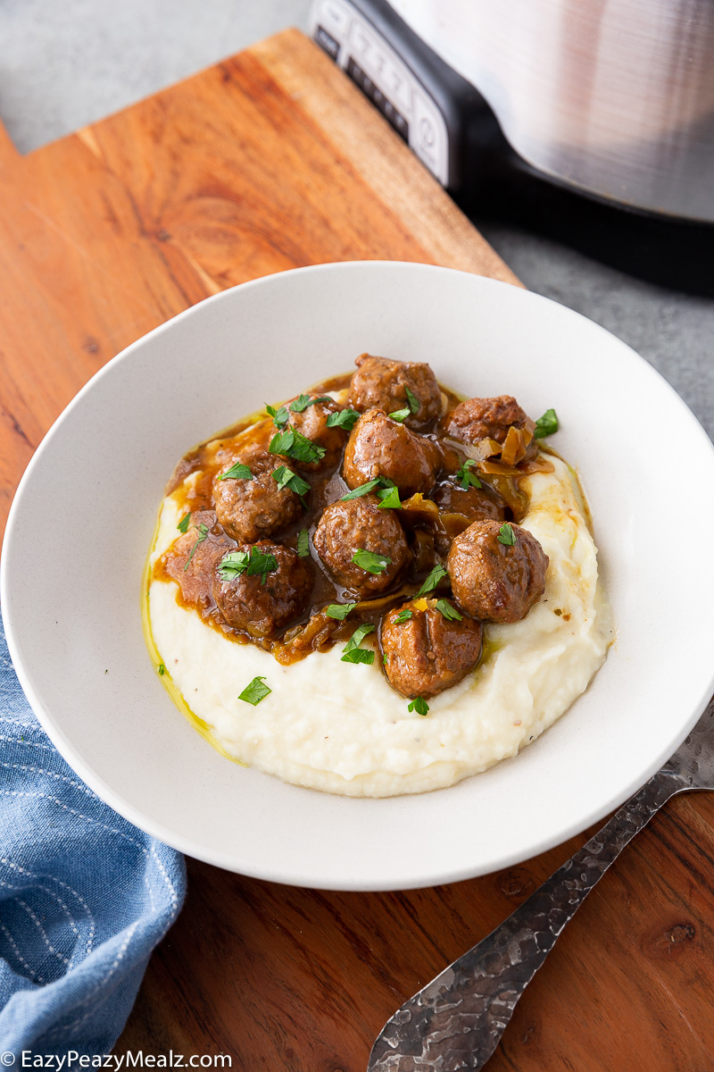 A plate full of mississippi meatballs spooned over mashed potatoes