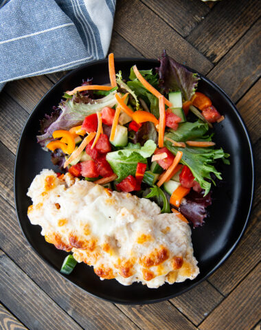 Caesar chicken bake on a plate with salad.
