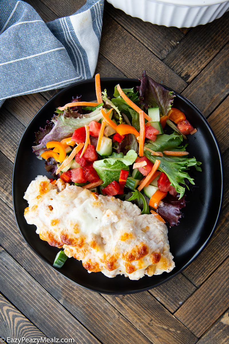 Caesar chicken bake on a plate with salad. 