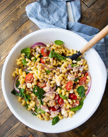 Chicken pasta salad with bacon, feta, spinach, red onion, and tomatoes.
