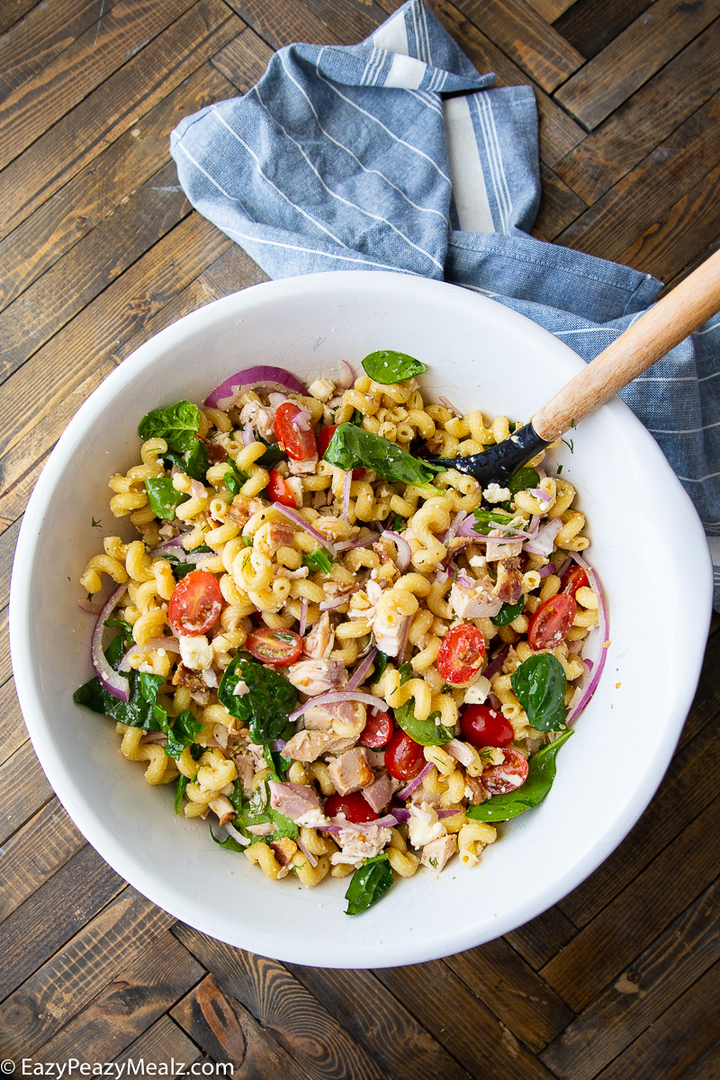 Chicken pasta salad with bacon, feta, spinach, red onion, and tomatoes. 