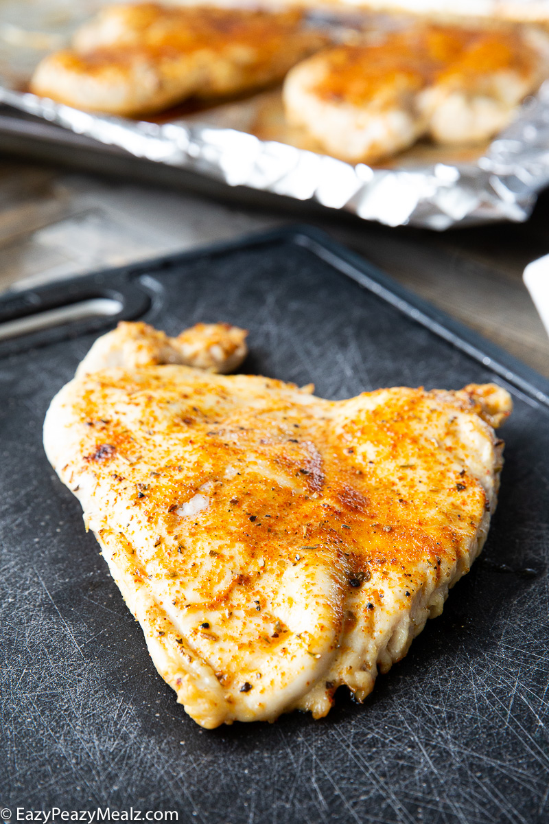 Juicy baked chicken breast on a cutting board