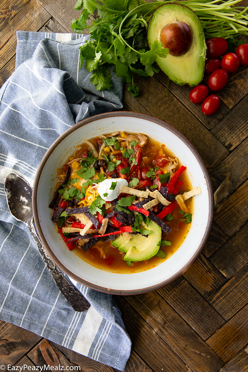 A bowl of chicken tortilla soup made in the slow cooker. 