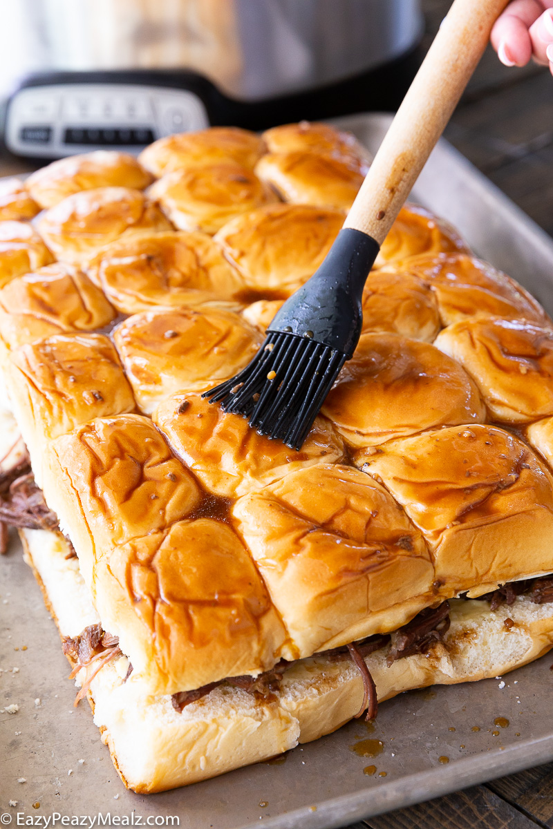 Brushing the tops of french dip sliders