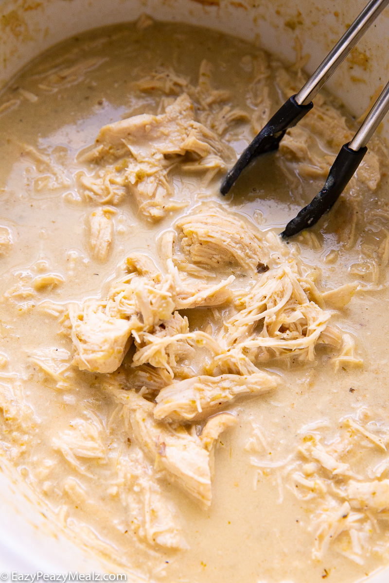 A crockpot full of slow cooker salsa verde queso chicken