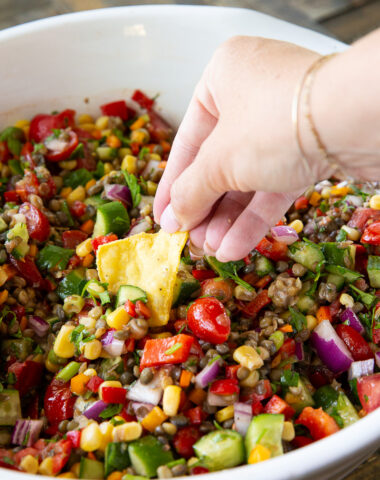 A bowl of lentil cowboy caviar being served with chips