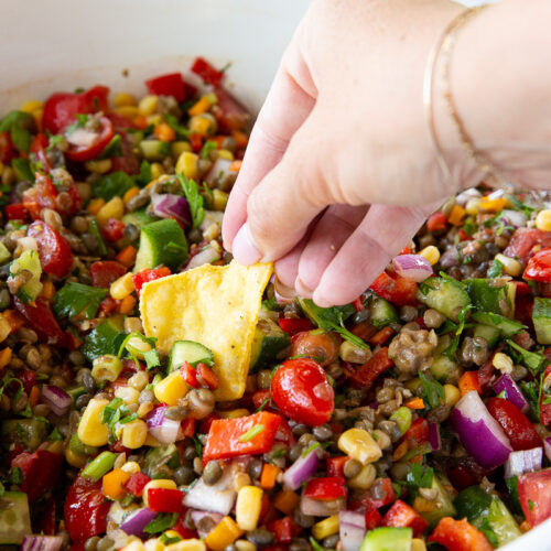 A bowl of lentil cowboy caviar being served with chips