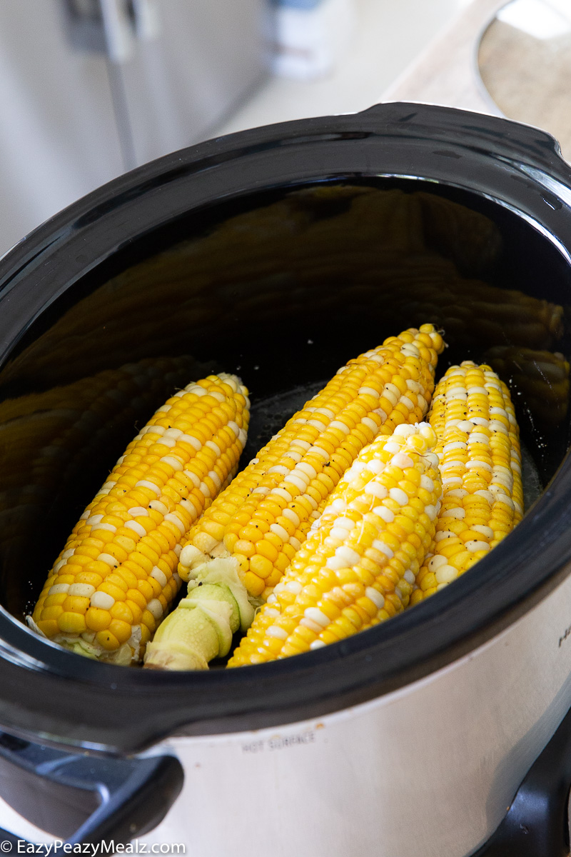 A crock full of slow cooked corn on the cob.