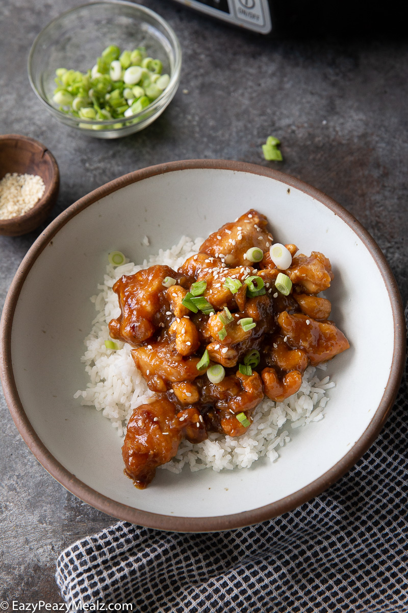 Slow cooker cashew chicken garnished with green onion